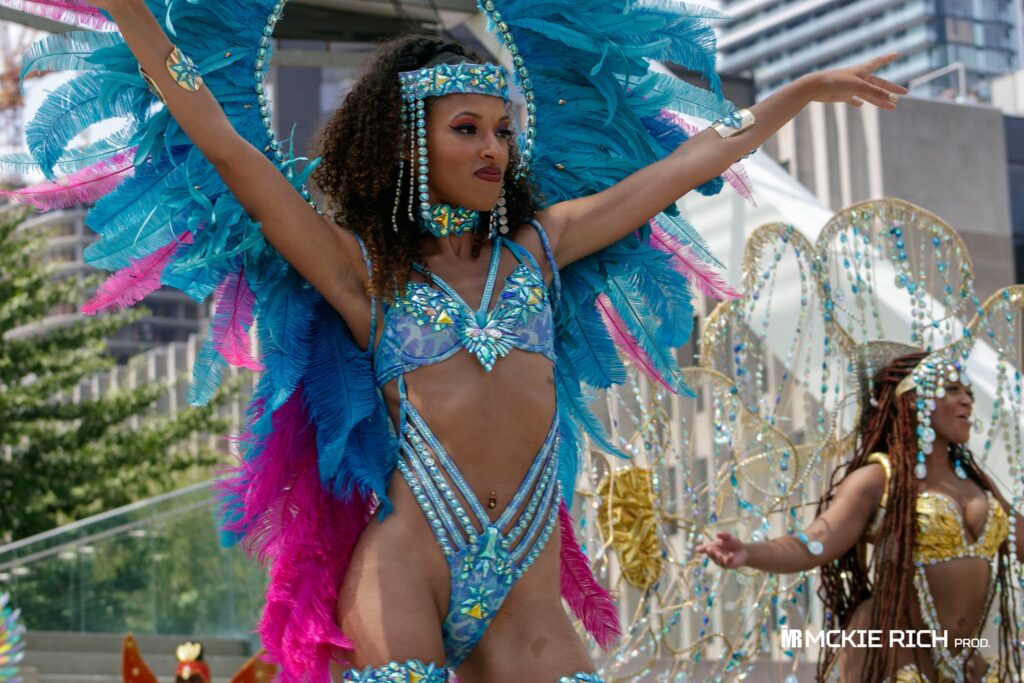 Masquerader in a costume from Sunlime Mas at Toronto carnival official launch at Nathan Phillips Square in downtown Toronto. Register to play mas at Toronto Carnival with Sunlime Mas.